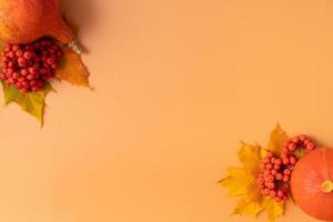höstens sammansättning. torkade löv, pumpor och rönnbär på orange bakgrund. höst, höst, thanksgiving day koncept. platt låg, ovanifrån, kopieringsutrymme. foto