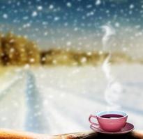 kopp varmt te och vinterlandskap foto