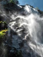 fallande vatten i ett vattenfall skapar ett moln av vattendamm. foto