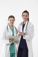 två kvinnliga sjukvårdsarbetare som bär uniform och stetoskop. foto