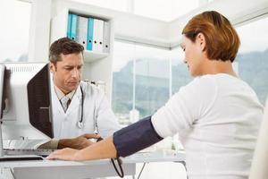 läkare som kontrollerar blodtrycket av kvinnan på medicinskt kontor