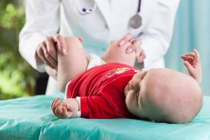 läkare undersöker liggande baby