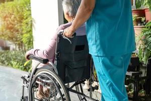 vårdgivare hjälp och vård asiatisk senior eller äldre gammal dam kvinna patient sitter i rullstol på rampen på vårdsjukhuset, hälsosamt starkt medicinskt koncept foto