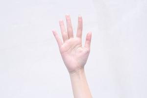 ung kvinna visar vacker hand agerade fem fingrar vände upp på den isolerade vita bakgrunden. foto