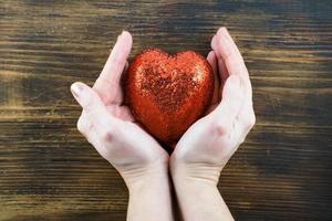 person som håller ett handgjort rött hjärta i hennes händer. kärlek. den 14 februari. alla hjärtans dag foto