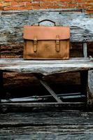brun läder laptop väska företag på gamla trästol foto