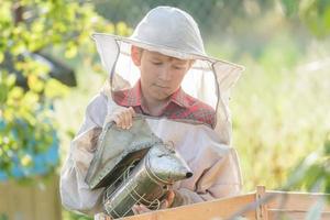 tonåring biodlare inspekterar kommersiella bin gård