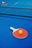 pingpongracket och boll och nät på pingpongbordet