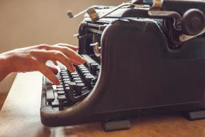 kvinna händer skriver på en gammal vintage dammtäckt skrivmaskin foto