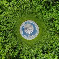 blå sfär liten planet inuti grönt gräs rund ram bakgrund. foto