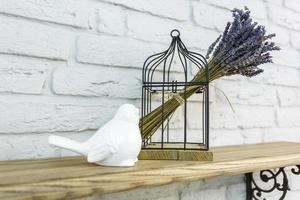 inredningsleksaker. vit dekorativ fågel nära bur i dyr interiör foto
