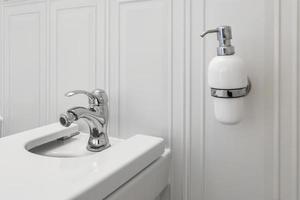toalett och detalj av en hörnduschbidé med tvål- och schampoautomater på väggfäste för dusch foto