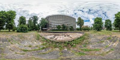 fullständig sömlös panorama 360 gånger 180 graders vinkel vy fasad av övergivna flervånings, kollapsande hotell nära torr tom fontän i ekvirektangulär sfärisk ekvidistant projektion. vr ar innehåll foto