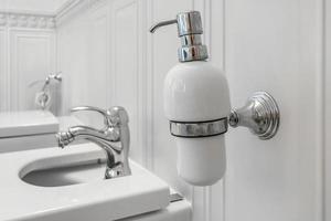 toalett och detalj av en hörnduschbidé med tvål- och schampoautomater på väggfäste för dusch foto