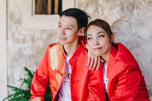 lyckliga unga asiatiska par i traditionella kinesiska klänningar foto