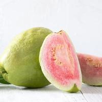 närbild av vacker röd guava med färska gröna blad. foto