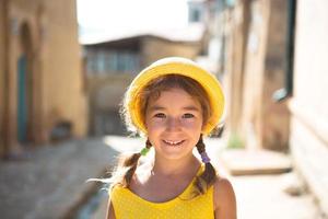 närbild av ett sommarporträtt av en flicka i en gul hatt och solklänning. solig sommartid, frihet, foto