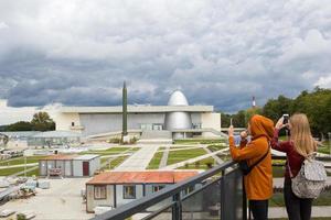 ryssland, kaluga, 14 augusti 2020. kaluga museum för kosmonautik. turister tar bilder på telefonen av attraktionen. raket, planetarium kupol, rekonstruktion, konstruktion av den andra linjen foto