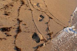 fotspår i sanden på stadsstranden. foto