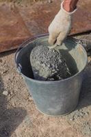byggnadsarbetare som blandar betongcement och sand med spade. foto