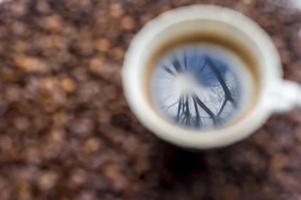 kopp kaffe på kaffebönor bakgrund foto