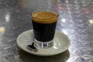 varmt och starkt kaffe hälls upp i en kopp. foto