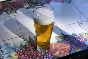 på bordet i ett glas färsk och kall öl. foto