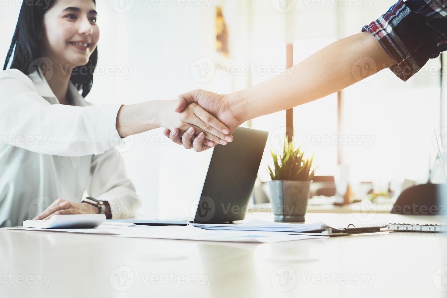 jonge zakenvrouw werkt samen met partners om hun bedrijfsinvesteringsnetwerk te vergroten voor plannen om de kwaliteit volgende maand op hun kantoor te verbeteren. overeenkomst begrip. foto