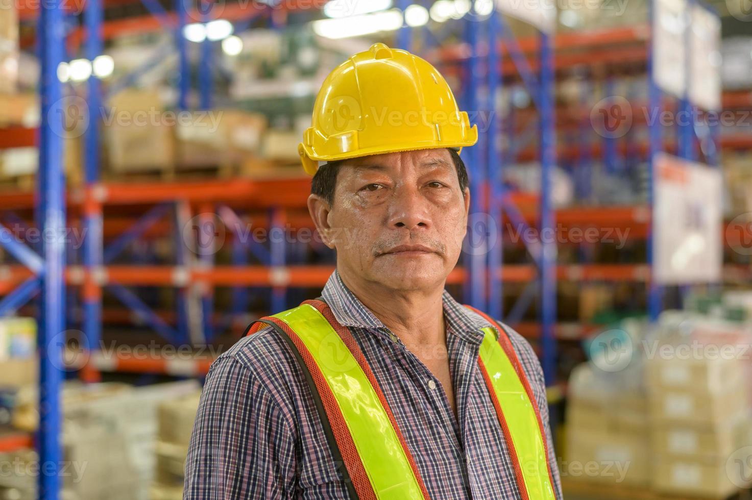 portret van een senior aziatische mannelijke werknemer die een helm draagt in een moderne magazijnopslag van een winkel? foto