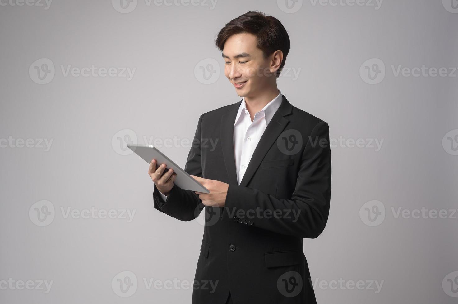 jonge zakenman die kostuum over witte achtergrond draagt studio foto