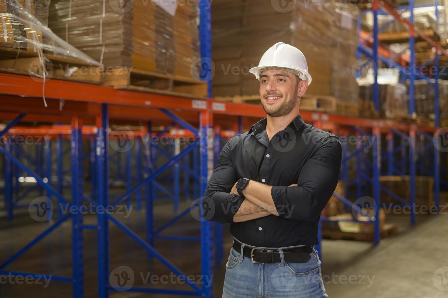 portret van een jonge blanke mannelijke werknemer die een helm draagt in een moderne magazijnopslag van een winkel? foto