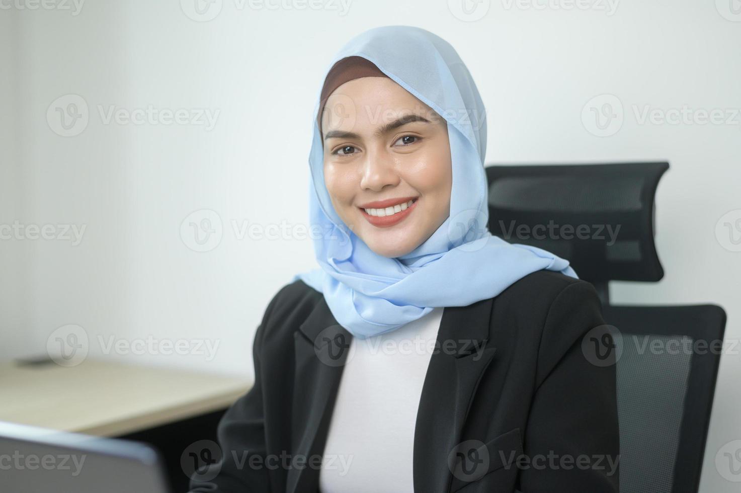 jonge moslim zakenvrouw die op laptop werkt met documenten in moderne kantoren foto