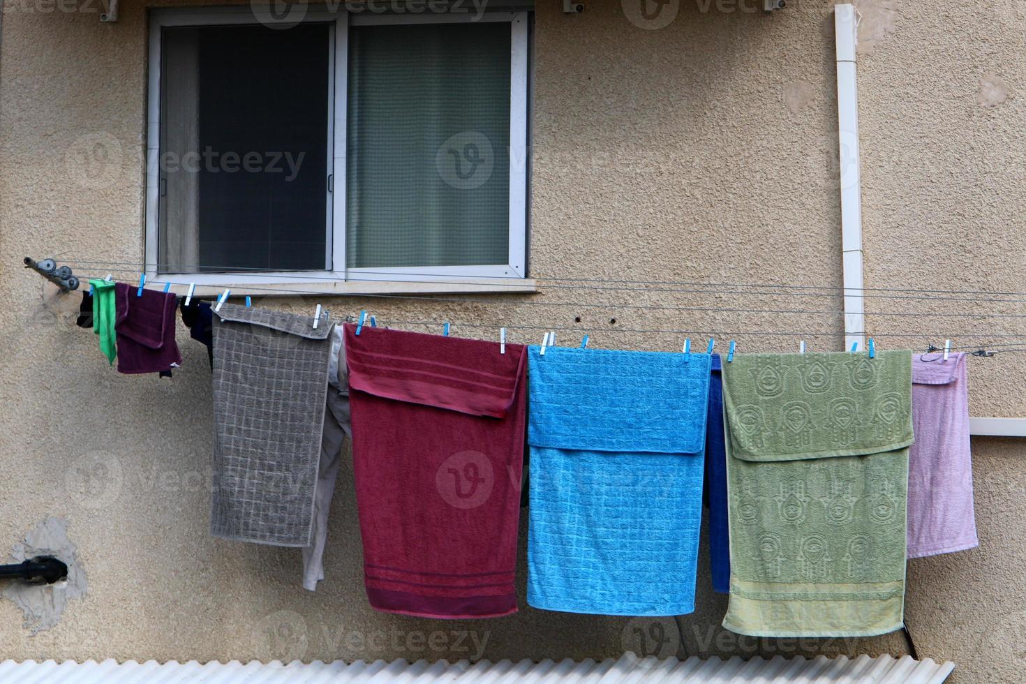 gewassen linnen droogt op straat buiten het raam van het huis. foto