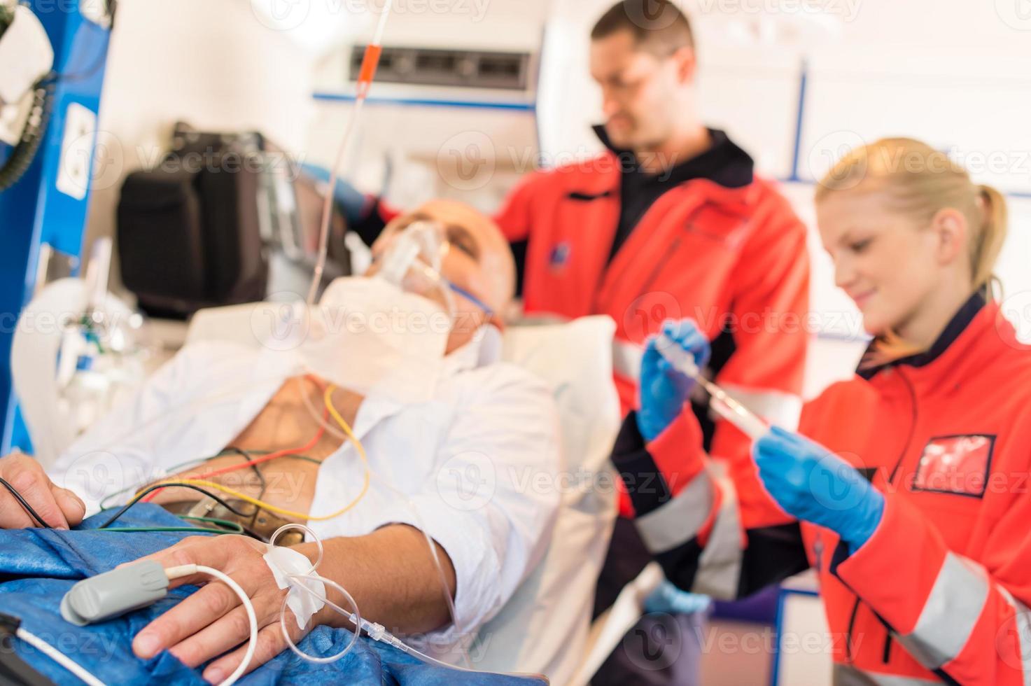 zieke patiënt wordt behandeld door paramedici in een ambulance foto