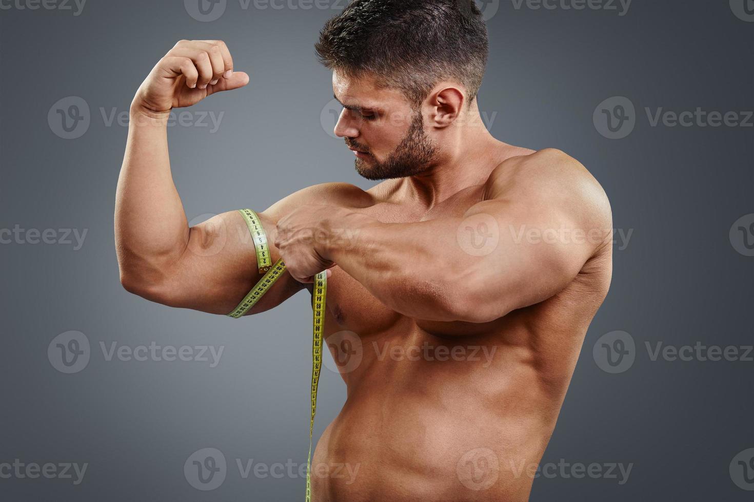 bodybuilder die biceps met meetlint meet foto