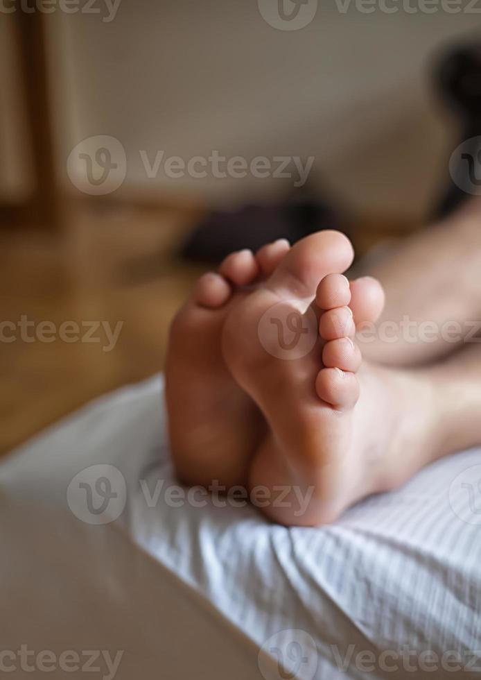 benen van een man in bed slapen foto
