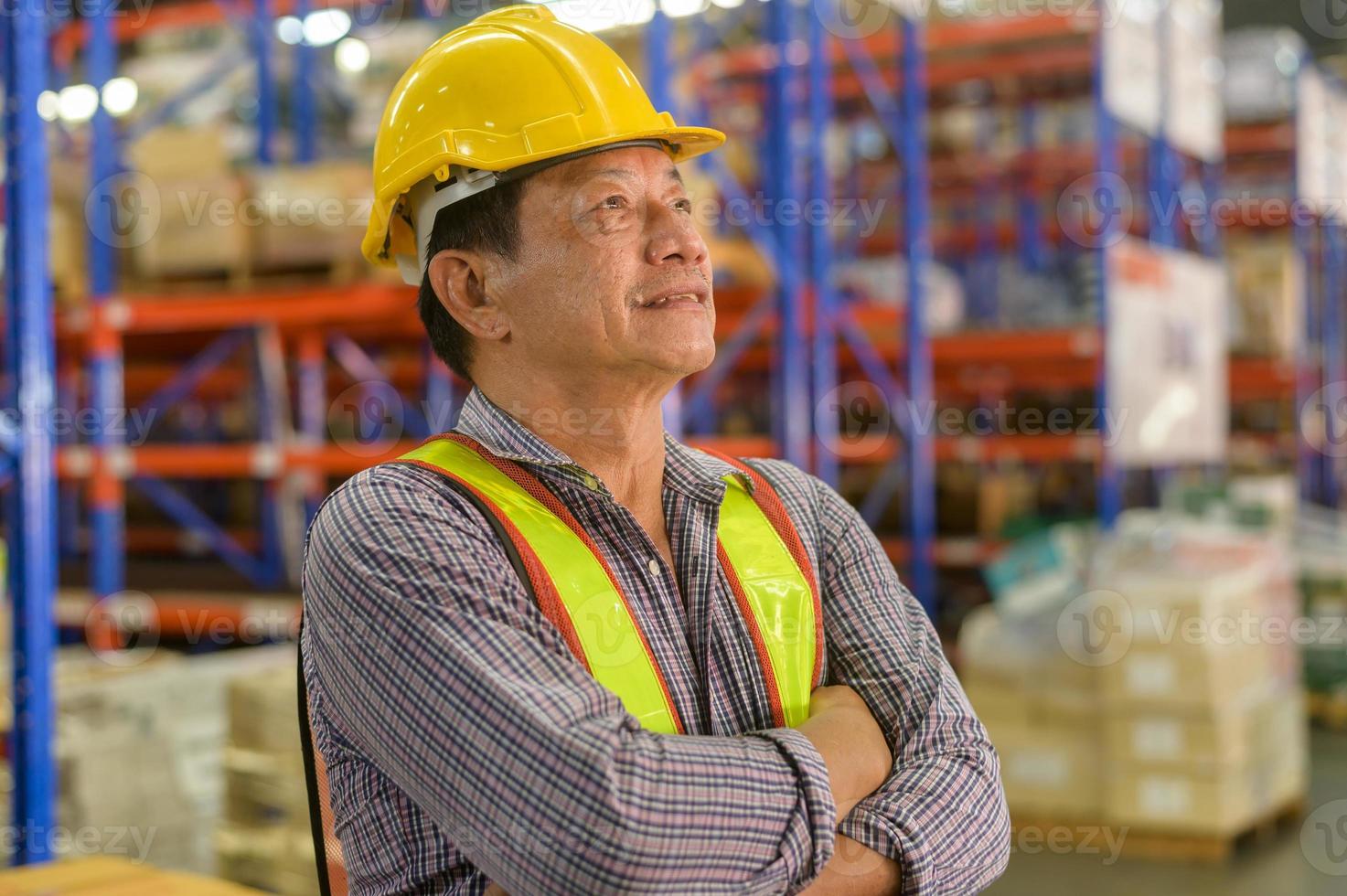 portret van een senior aziatische mannelijke werknemer die een helm draagt in een moderne magazijnopslag van een winkel? foto