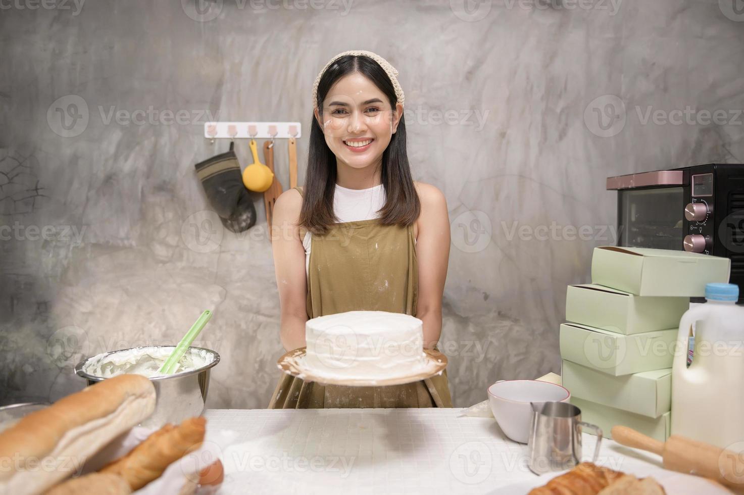 jonge mooie vrouw bakt in haar keuken, bakkerij en coffeeshopbedrijf foto