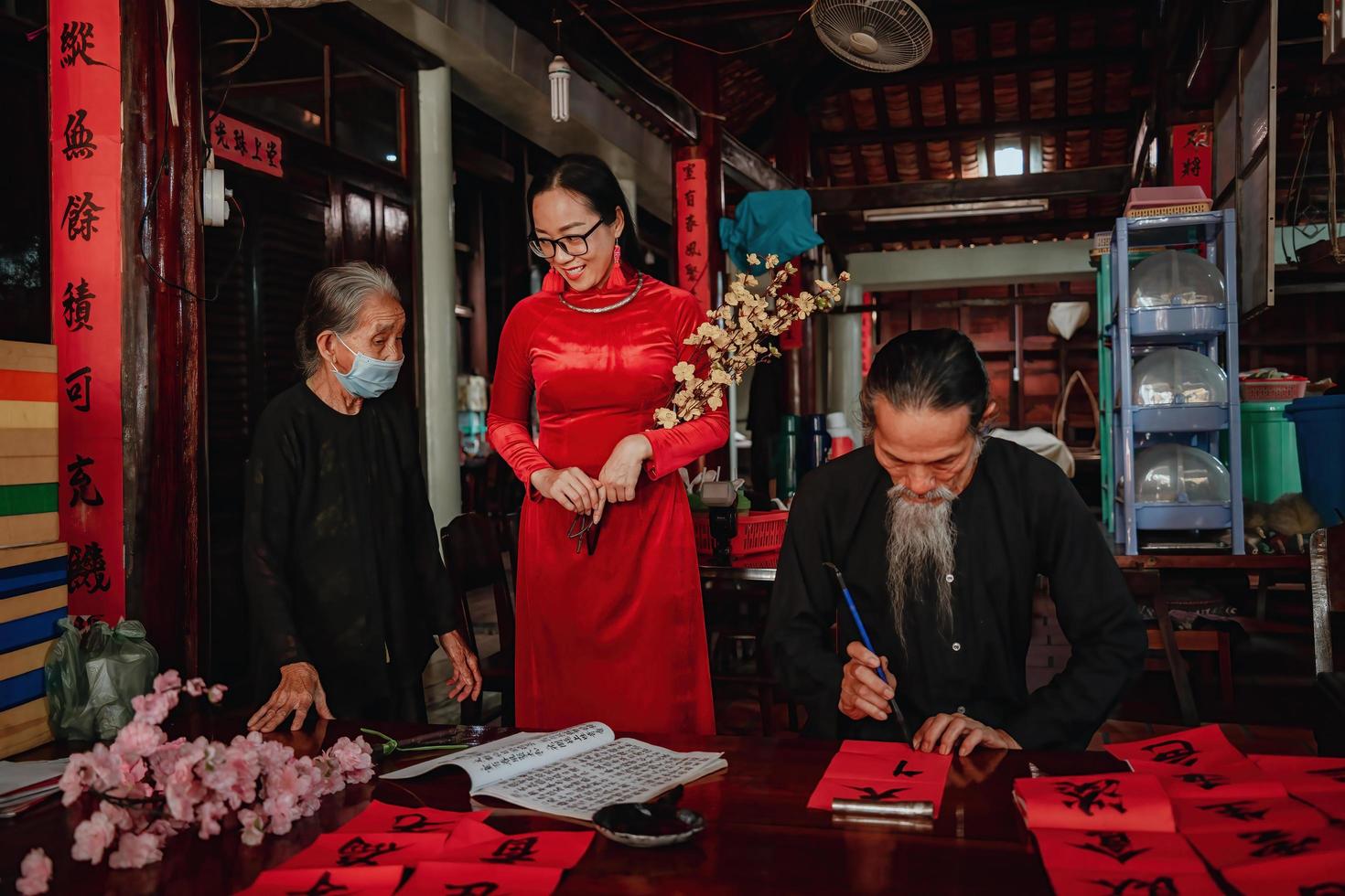 Vietnamese geleerde schrijft kalligrafie bij lange zoon. kalligrafiefestival is een populaire traditie tijdens de tet-vakantie. schrijven van coupletten voor lentefestival, nieuwjaar. foto