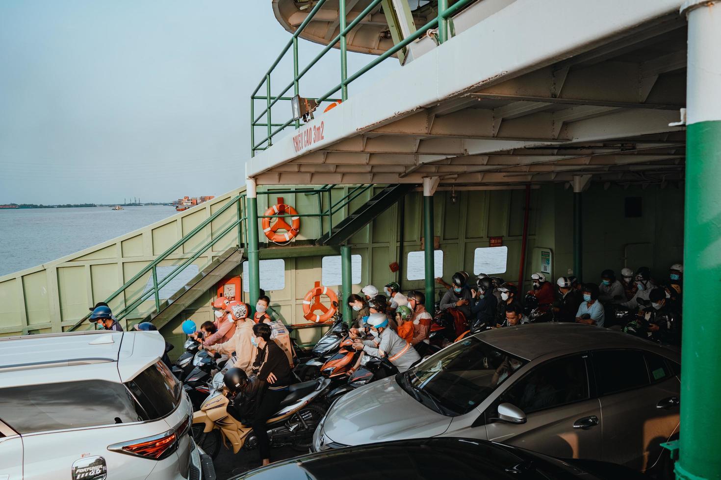 ho chi minh, vietnam - 19 februari 2022 een veerboot brengt forenzen en voertuigen van de nieuwe haven van Cat Lai naar de overkant van de rivier de Nha Be. ho chi minh-stad is de grootste stad in vietnam 9 mln foto