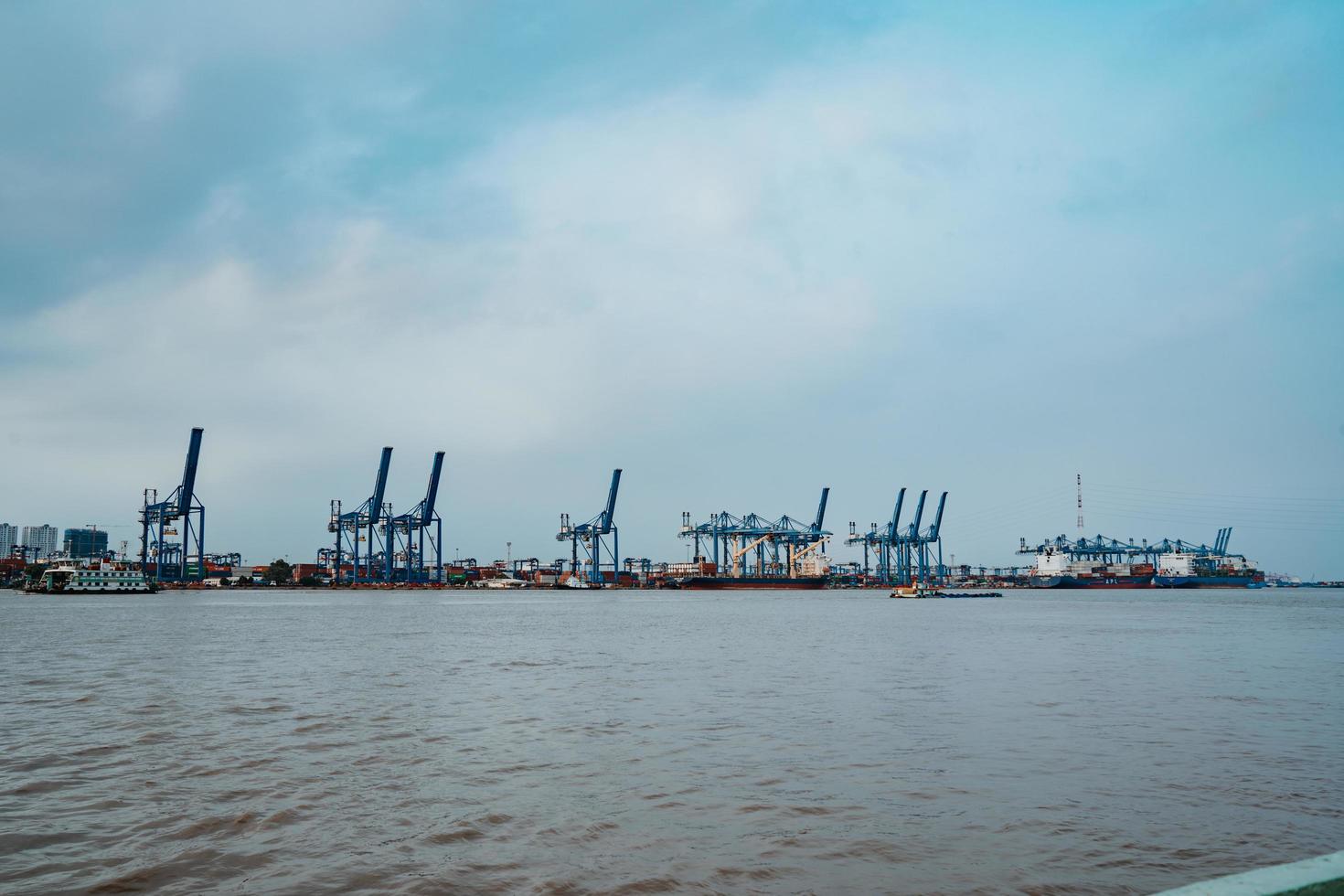 ho chi minh, vietnam - 19 februari 2022 transport voor export, import in cat lai port aan de sai gon-rivier, kraanlaadcontainer naar boot, deze haven is een grote industriële service voor handel foto