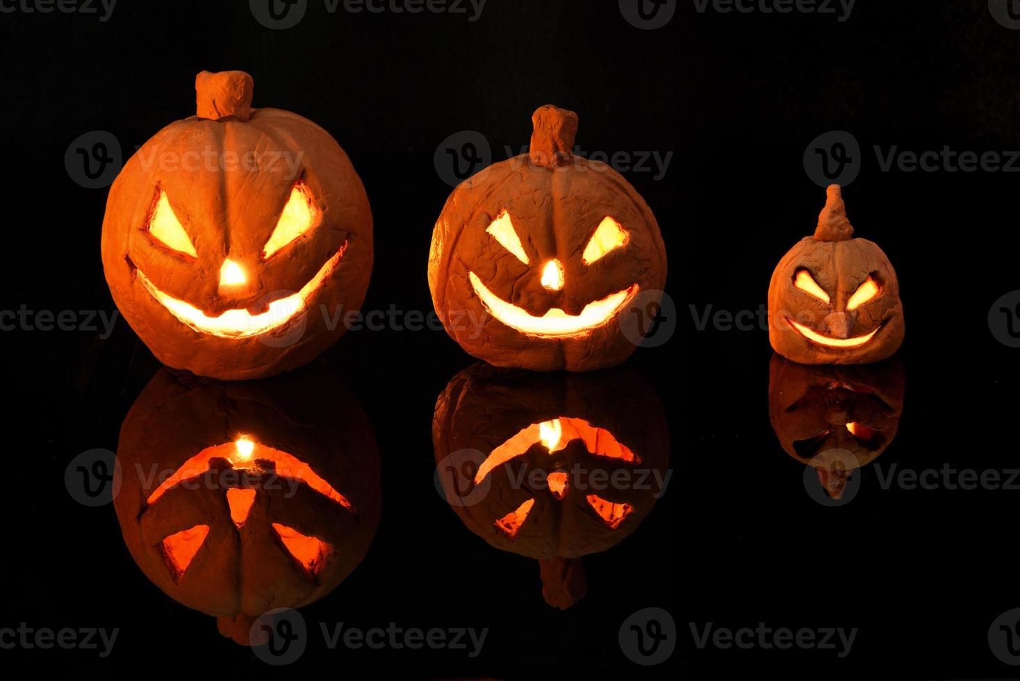 Halloween-pompoen met brandende kaarsen op zwarte achtergrond foto