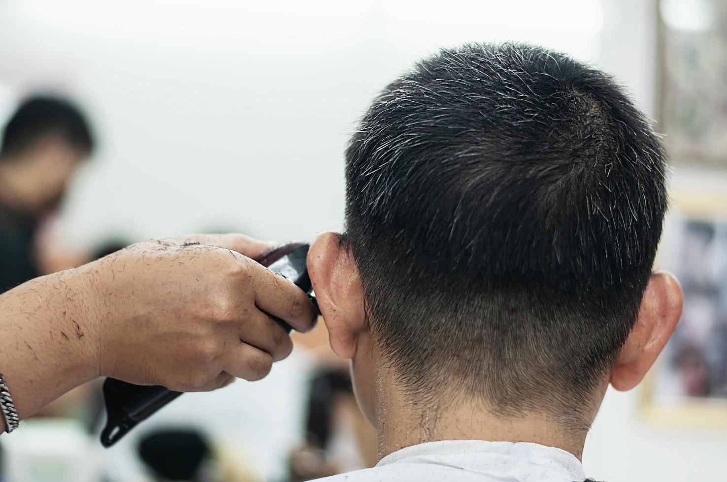 man is geknipt zijn haar in kapperszaak - mensen in kapper schoonheidssalon concept foto