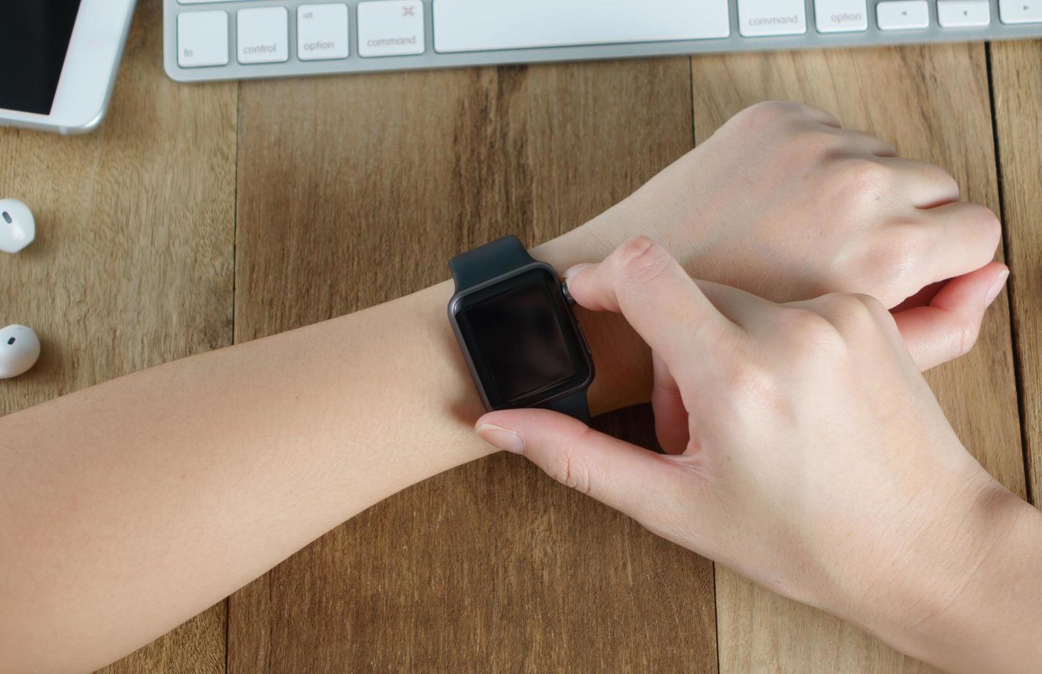 vrouw die slim horloge gebruikt op het bureau foto