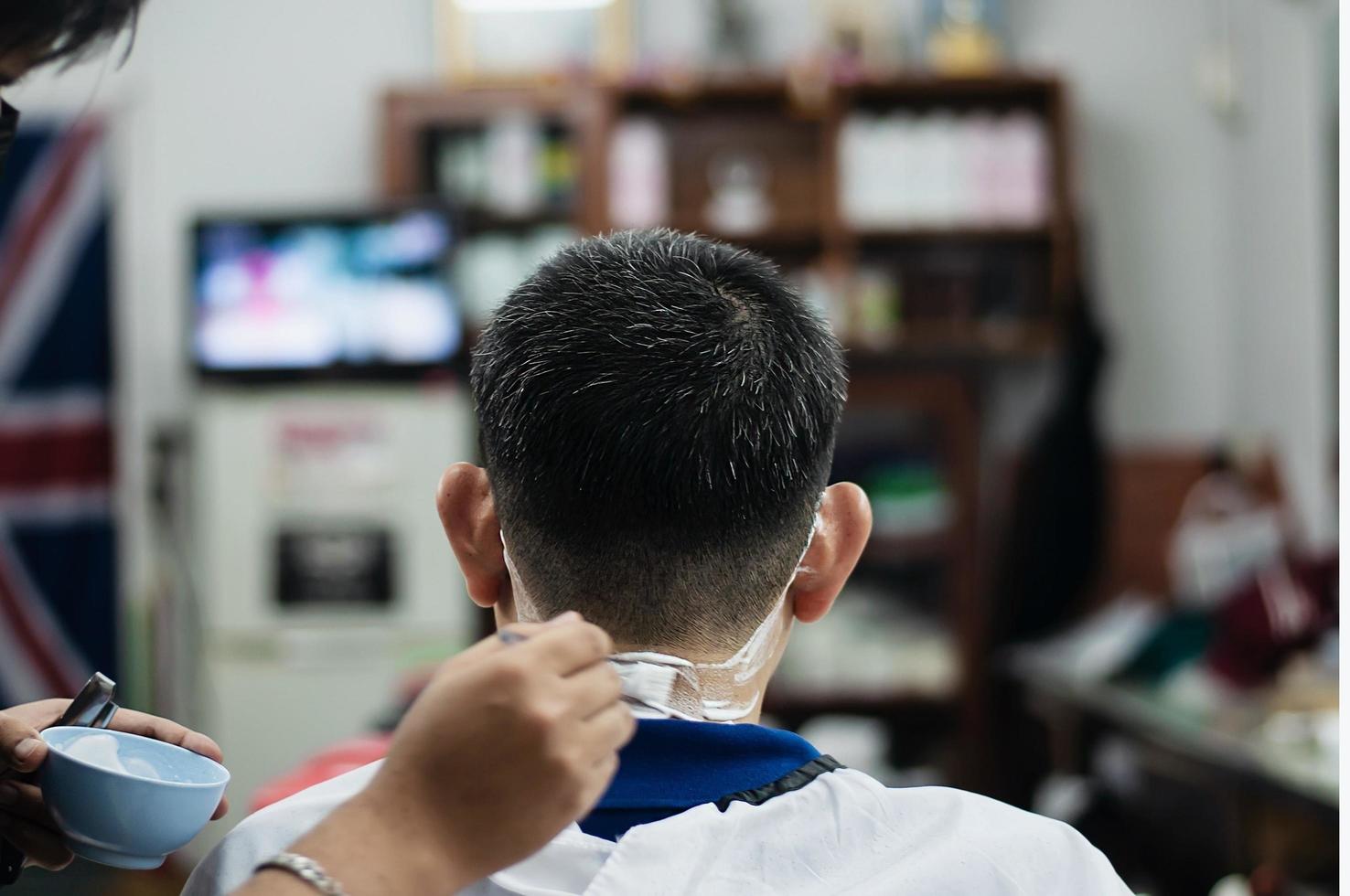 man is geknipt zijn haar in kapperszaak - mensen in kapper schoonheidssalon concept foto