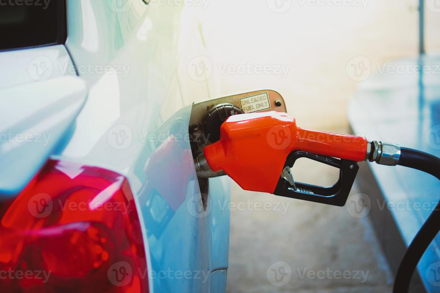 sproeiers van benzinestations. auto's die tanken in het tankstation. het concept van brandstofprijzen is veranderd. foto