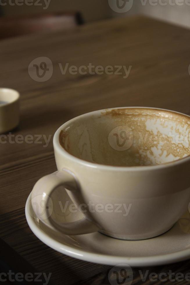 cappuccino-koffie in rode mok op houten cappuccino-koffie in mok op houten tafel foto