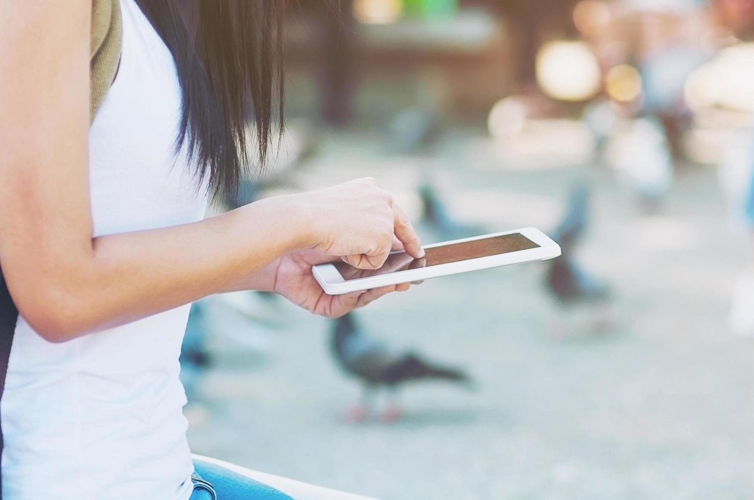 jonge vrouw rugzak reiziger met behulp van tablet in de stad - outdoor aziatische reiziger activiteit concept foto