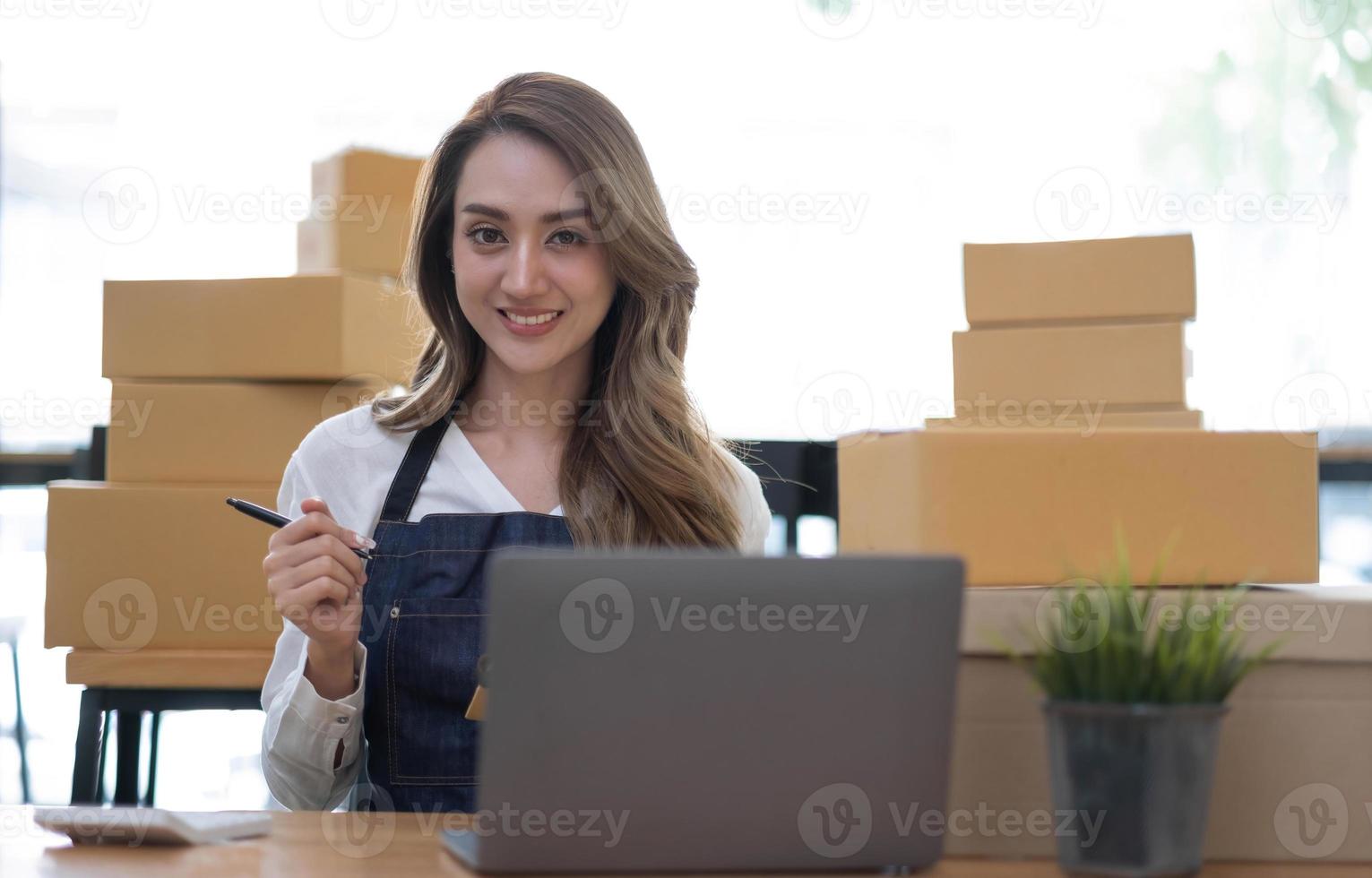 portret van aziatische jonge vrouw mkb werkend met een doos thuis de werkplek. start-up kleine ondernemer, kleine ondernemer mkb of freelance bedrijf online en leveringsconcept. foto