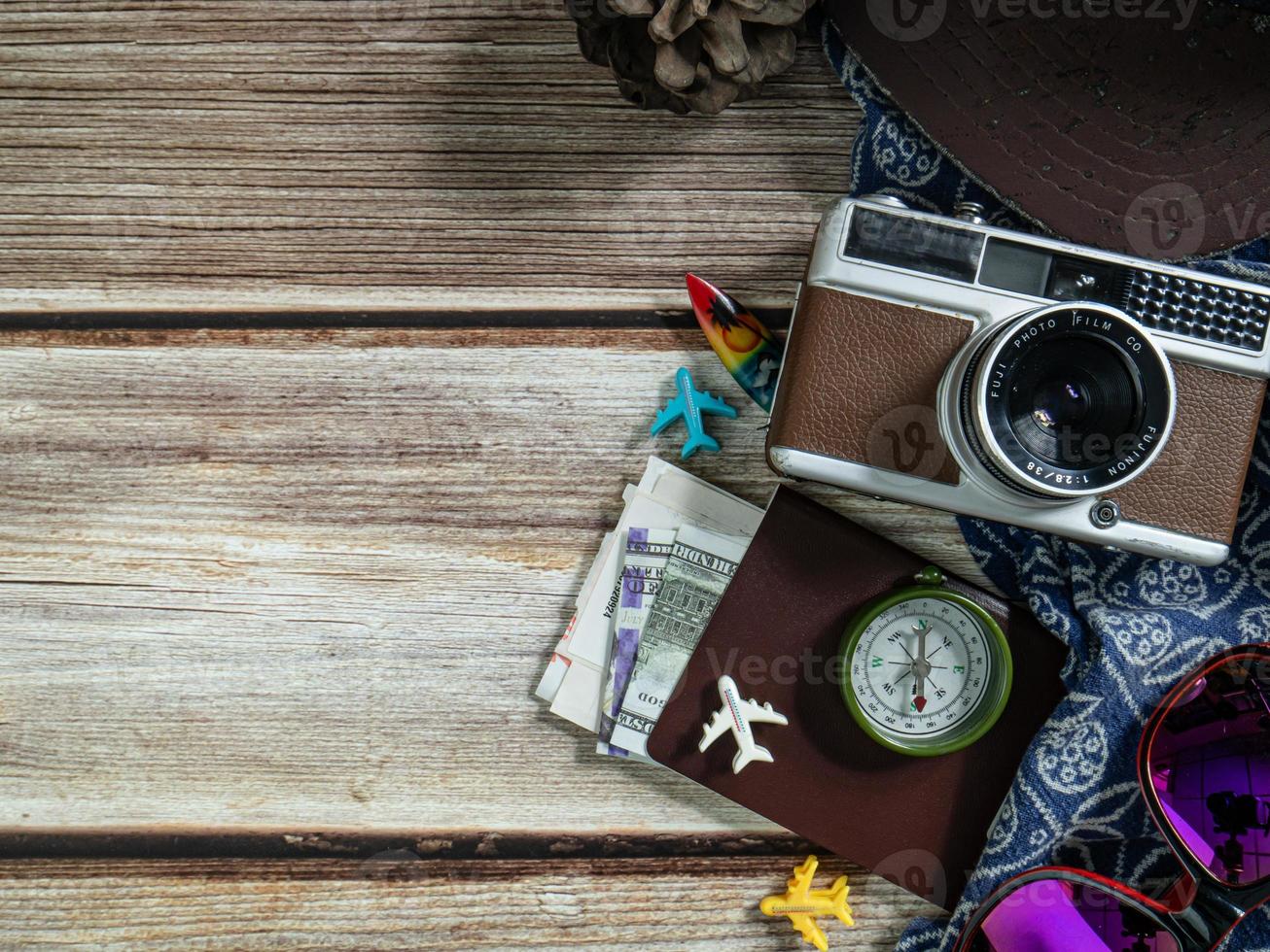 camera en paspoort op houten tafel voor reisconcept. foto